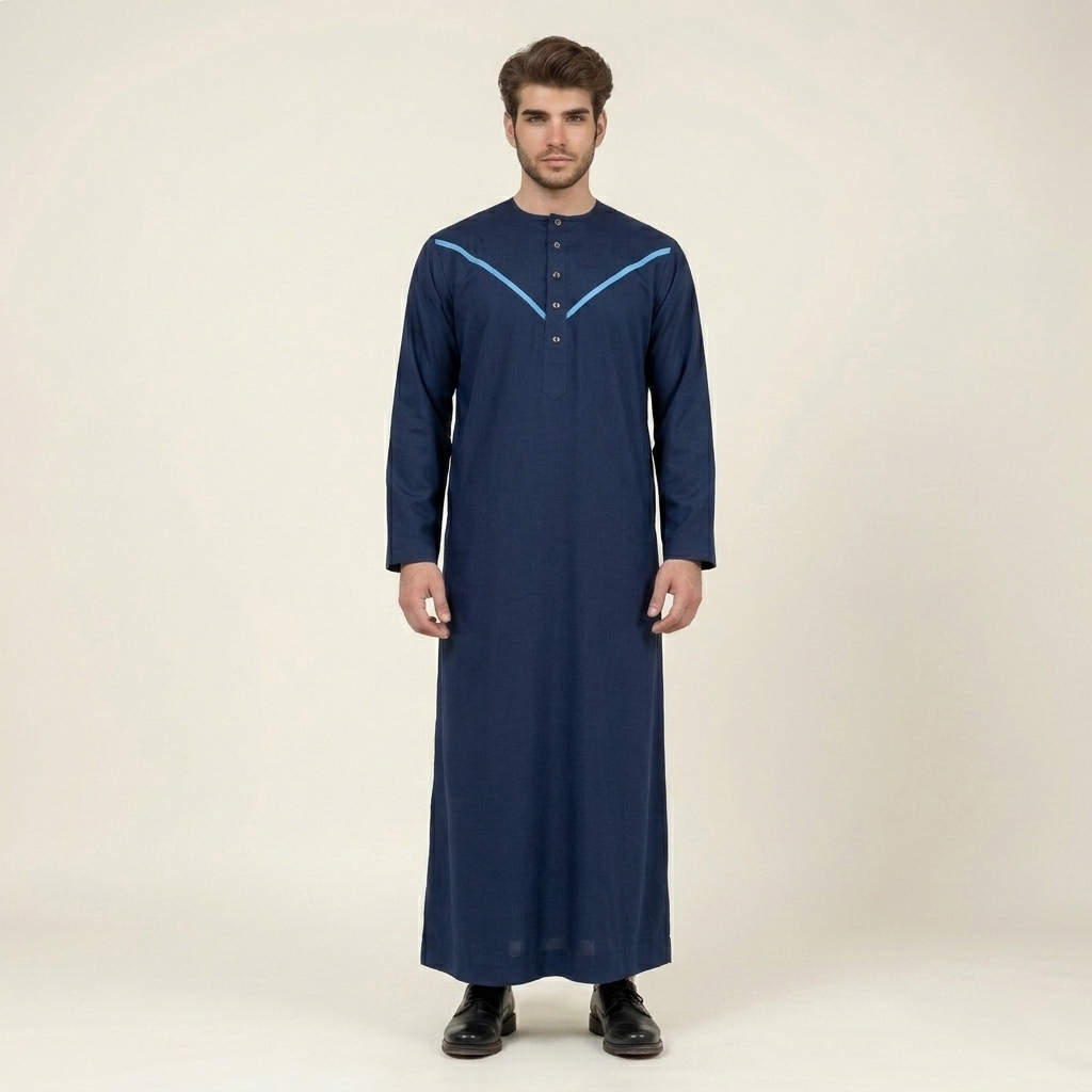 Elevate your style with our Omani Style Navy Blue Mens Thobe, designed to blend traditional elements with modern detailing. Featuring a deep navy base with striking sky blue accents, this thobe offers a refined and contemporary look suitable for formal gatherings, prayers, and everyday wear. Its structured design and premium fabric ensure both comfort and sophistication. Design & Cut This thobe is tailored with a straight-cut silhouette that provides a clean and structured appearance. The signature V-stitch yoke across the chest adds a bold geometric detail, enhancing the overall design with a modern touch. Fabric Crafted from premium wash & wear fabric, the material is wrinkle-resistant and easy to maintain. It retains a smooth and crisp drape throughout the day while ensuring durability and long-lasting wear. Collar / Neckline The thobe features a modern collarless round neckline, offering a comfortable and streamlined fit. This minimalist design enhances both style and ease of wear. Closure & Pockets A neat front placket with vertically aligned buttons adds a refined and professional detail. The design maintains a clean aesthetic while ensuring functionality and convenience. Sleeves The full-length sleeves are designed for a polished finish, complementing the structured silhouette while allowing comfortable movement. Overall Design The Omani Style Navy Blue Mens Thobe stands out with its bold V-stitch detailing and rich color contrast. With its breathable fabric, modern tailoring, and traditional inspiration, it is a versatile choice for formal occasions and everyday elegance.